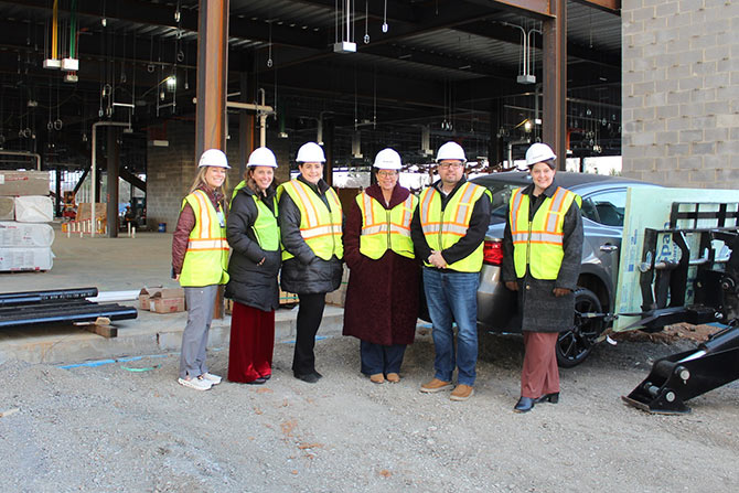 Workers in safety gear posing outside
