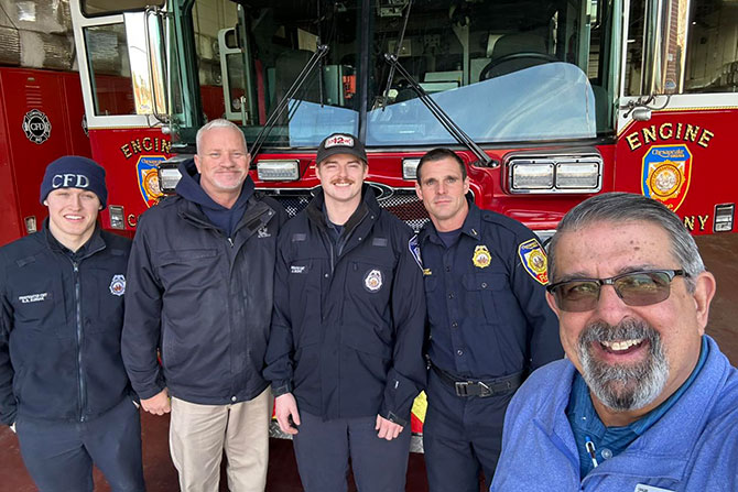 Smiling man with firefighters